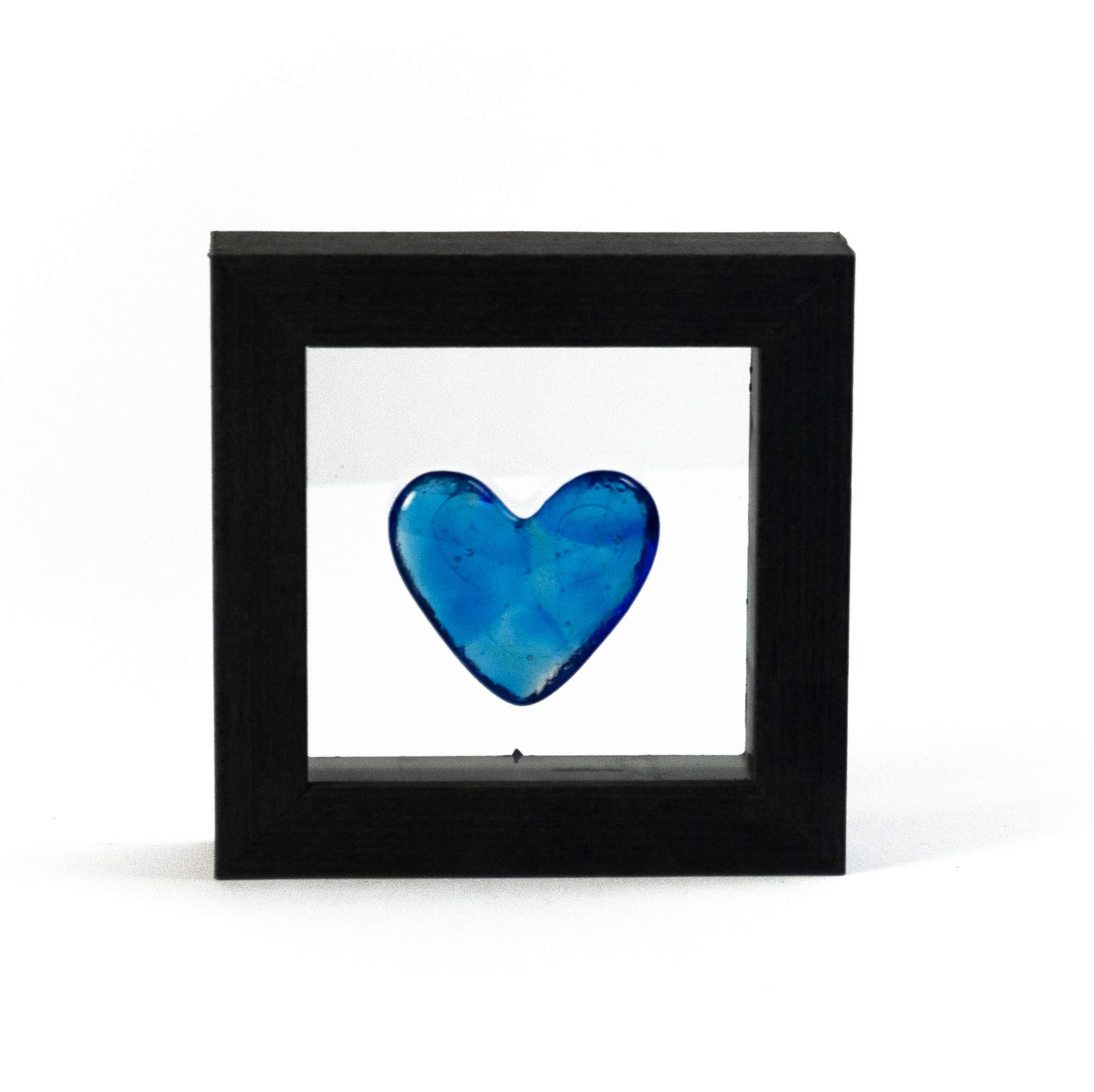 Small turquoise glass heart in a wood frame.